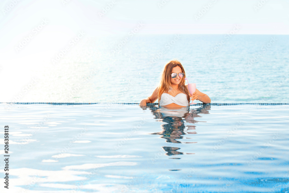 Summer Vacation. Woman in bikini on the inflatable donut mattress in the SPA swimming pool. Summer Vacation. Woman in bikini on the inflatable donut mattress in the SPA swimming pool.