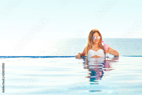 Summer Vacation. Woman in bikini on the inflatable donut mattress in the SPA swimming pool.