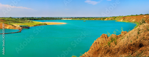 Artificial lake in the sand quarry. Sunny summer day.