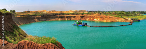 Beautiful lake in the sand quarry with the dredge photo