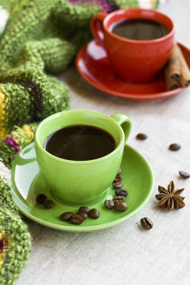 Green and red cups of coffee with coffee Bence, anise star and cinnamon Chopsticks