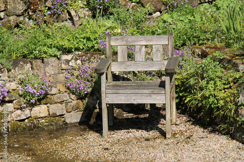 A Single Wooden Chair Seat on a Garden Terrace.