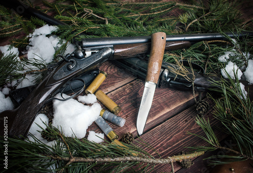 Hunting still life with a knife and two rifles. photo