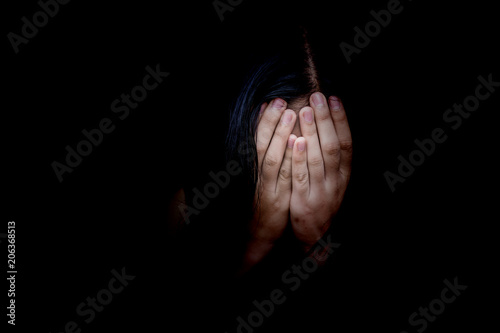 Concept of fear, domestic violence. Woman covers her face her hands