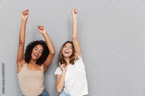 Portrait of two happy young women dancing photo