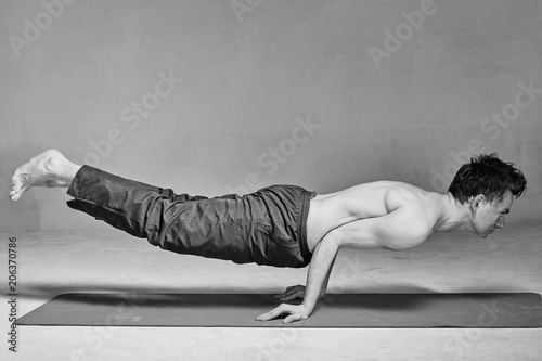 young man is engaged in yoga in a studio