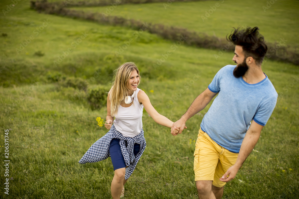 Couple enjoying a walk through grass land Couple enjoying a walk through grass land