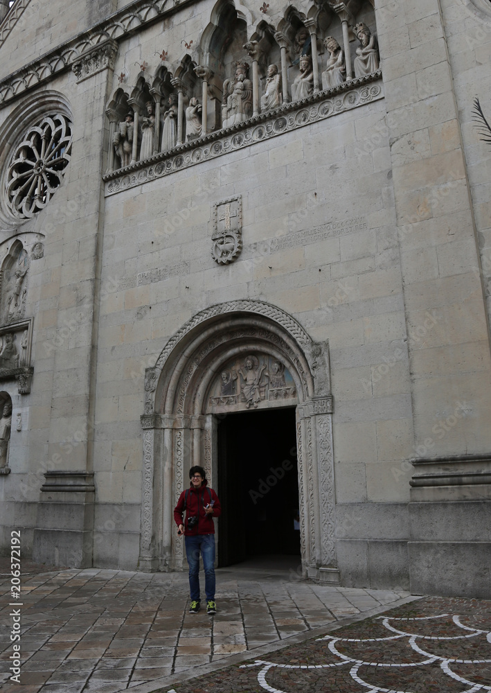 young boy go out of Cathedral of Gemona City in Italy