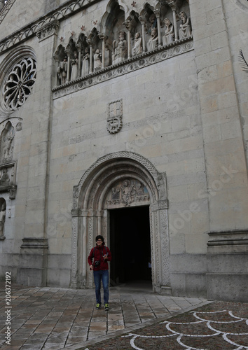 young boy go out of Cathedral of Gemona City in Italy