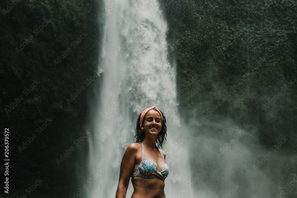 Young beautiful tourist visiting the nungnung waterfall in the bali island, indonesia. Having fun in the wild nature. Lifestyle. Travel photography.