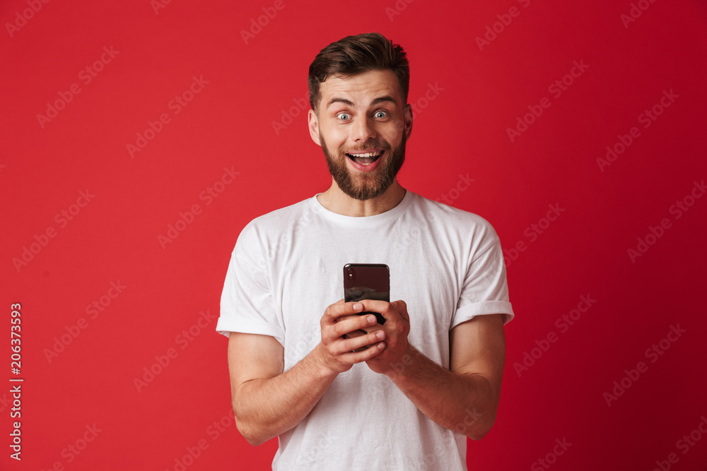 Shocked young man using mobile phone. Looking camera. Shocked young man using mobile phone. Looking camera.