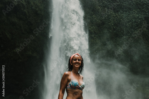 Young beautiful tourist visiting the nungnung waterfall in the bali island, indonesia. Having fun in the wild nature. Lifestyle. Travel photography.