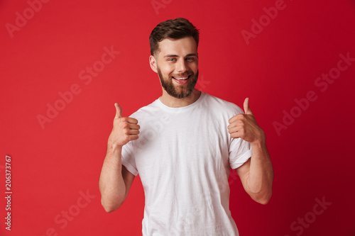 Handsome young smiling man make thumbs up gesture.