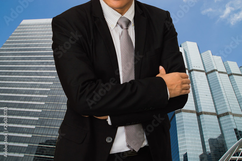 Young businessman standing on the back of a building in a business district. photo