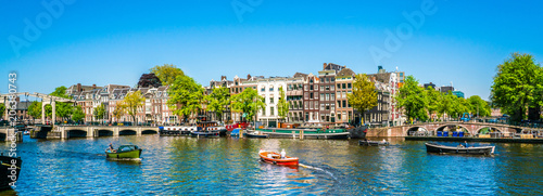 Amsterdam, May 7 2018 - view on the river Amstel filled with small boats and the Magere brug (skinny bridge) in the background on a summer day photo
