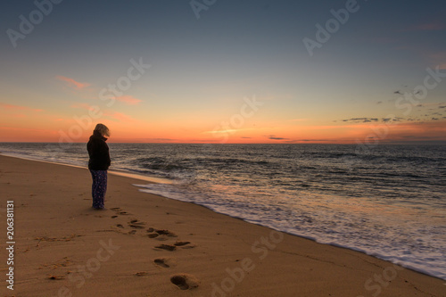 Woman watching the sunrise at the beach