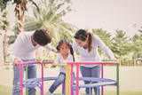 Family Concept. Happy male and female playing with children outside. Family is doing happy activities at Playground.  Parents are playing happily.