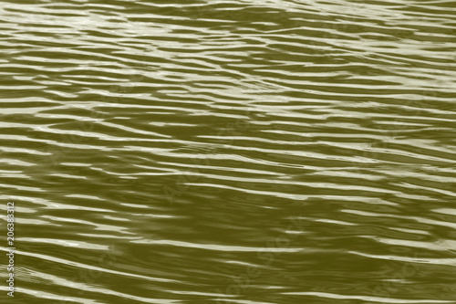 abstract background: waves on river colored in golden