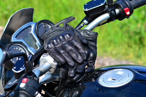 Moto gloves on the handlebars of a motorcycle.