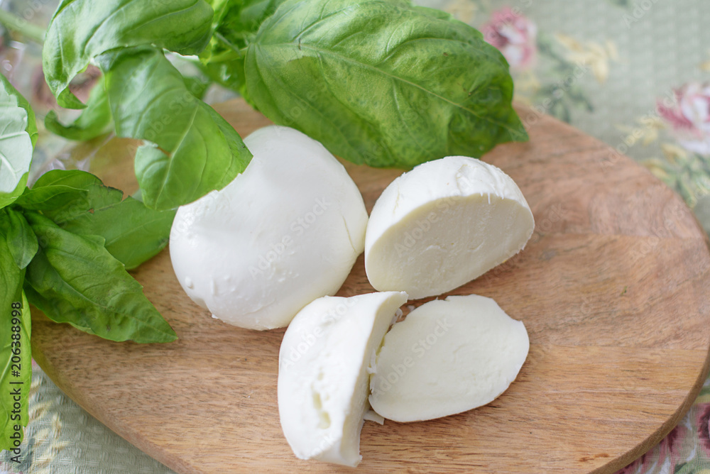 Mozzarella and basil on a cutting board Mozzarella and basil on a cutting board