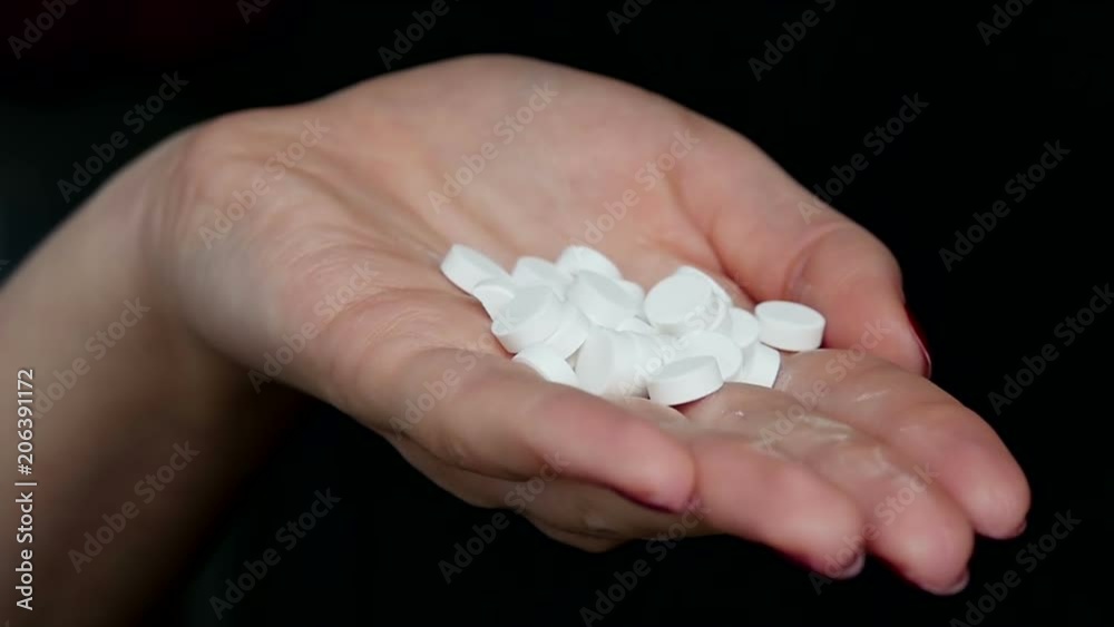 The girl closes her hand. Many white tablets. Concept of health. Medicine. The girl closes her hand. Many white tablets. Concept of health. Medicine.