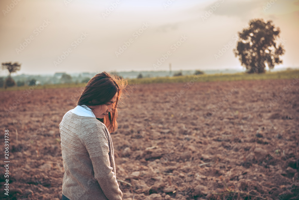 Portrait of lonely woman alone in a field. Vintage filter style.she heartbreak from love,sad girl concept on sunset vintage style