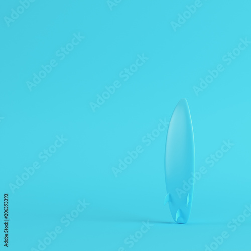 Surfboard on bright blue background in pastel colors. Minimalism concept