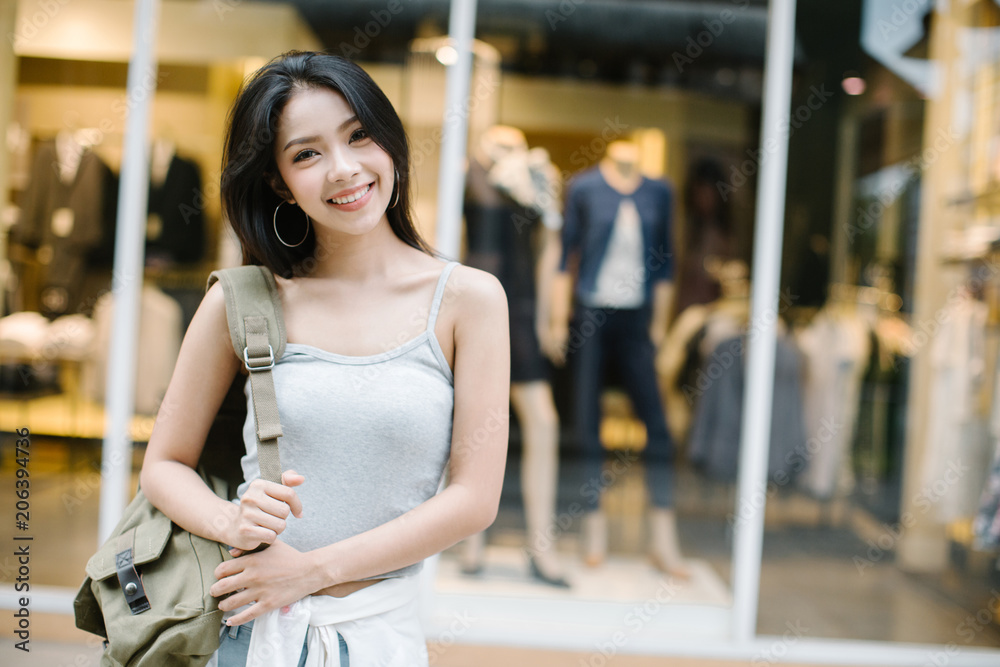 Summer sunny lifestyle fashion portrait of young stylish hipster woman walking on the street, wearing cute trendy outfit