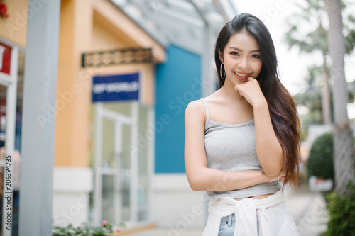 Summer sunny lifestyle fashion portrait of young stylish hipster woman walking on the street, wearing cute trendy outfit © uinmine