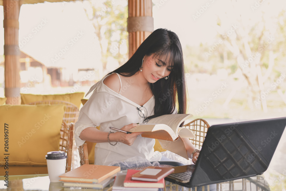Naklejka premium Business Concept.Young Asian businesswoman is working happily.Young businesswoman working in a cafe.Young businesswoman is relaxation in a coffee shop.