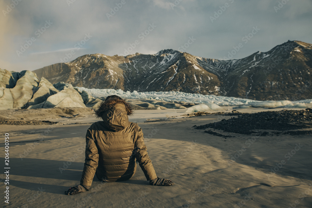 Young man sat staring at Vatnajokull Glacier