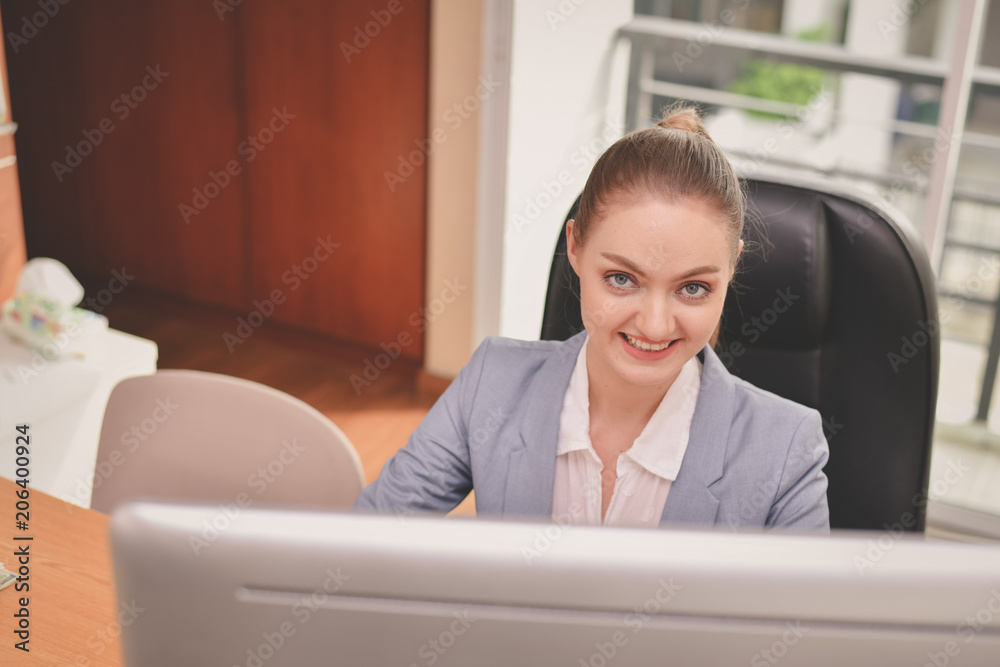 Business Concepts. Beautiful businesswoman is working in office. Beautiful young businesswoman is working on a computer. Beautiful young businesswoman is working happily. Business Concepts. Beautiful businesswoman is working in office. Beautiful young businesswoman is working on a computer. Beautiful young businesswoman is working happily.