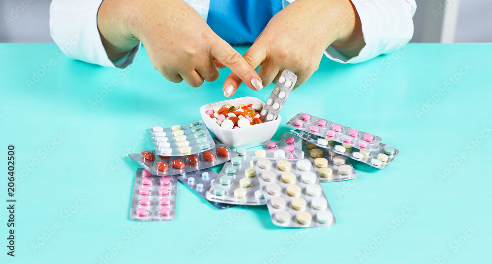 Female doctor hand hold pack of different tablet blisters at workplace. Panacea, life save service, prescribe medicament, legal drug store, disease healing, blood pressure concept. Letterbox view