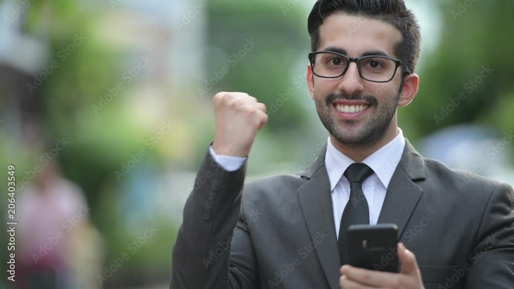 Young handsome bearded Persian businessman in the streets outdoors Young handsome bearded Persian businessman in the streets outdoors
