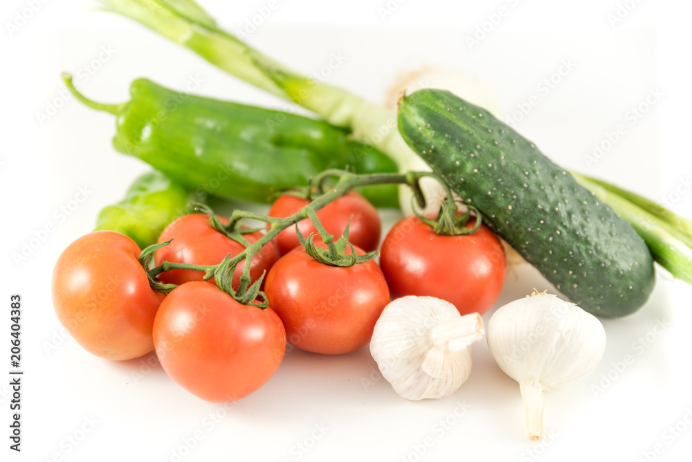 bunch of tomatoes, garlic, cucumbers, peppers and onions on white background
