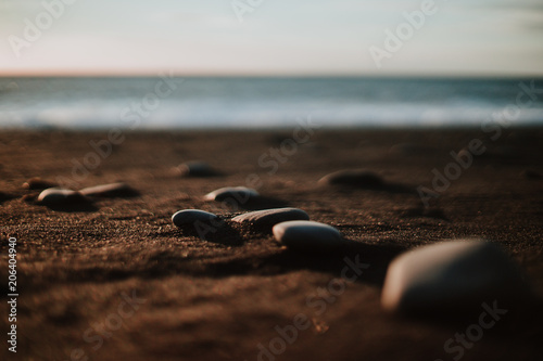 Some stones at a black sand beach in Iceland at sunset