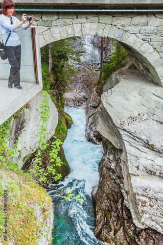 Tourist with camera on Gudbrandsjuvet waterfall, Norway photo