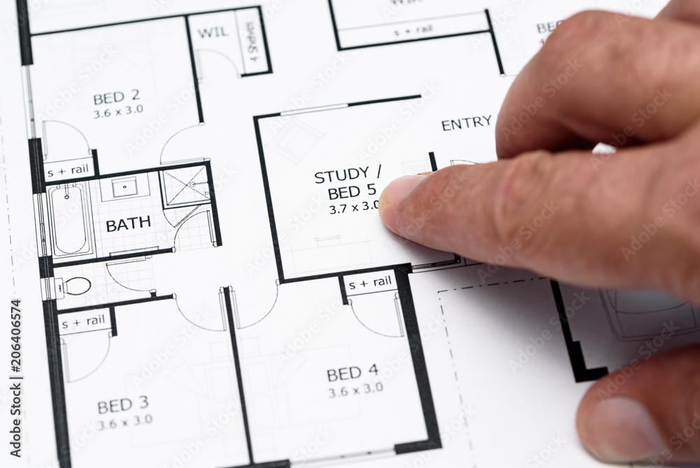 Mans finger pointing to house plans / diagram Mans finger pointing to house plans / diagram