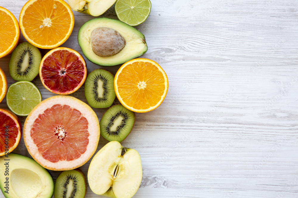 Various fresh fruits on white wooden surface with copy space, top view. Summer background. Various fresh fruits on white wooden surface with copy space, top view. Summer background.