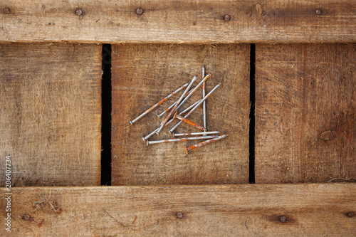 Rusty nails on dark wood texture background surface with old natural pattern photo