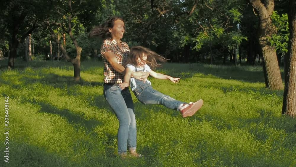 Happy family in the park. Mother circling daughter. Happy family in the park. Mother circling daughter.