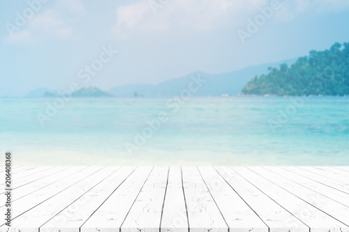 Perspective white pearl wooden table on top over blur sea in sunny day background. Beautiful sea and clouds in Thailand on summer  can be used mock up for montage products display or design layout.