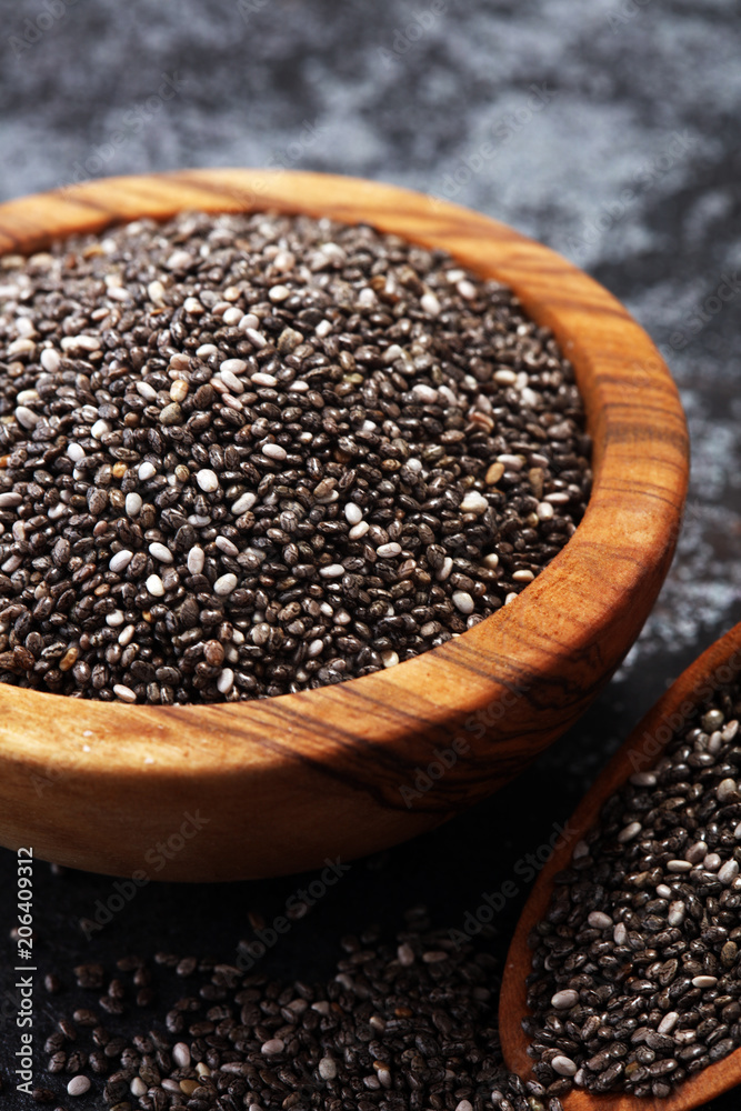 Healthy Chia seeds in a wooden spoon on the table close-up Healthy Chia seeds in a wooden spoon on the table close-up