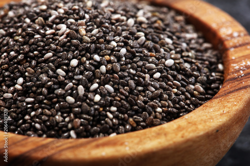 Healthy Chia seeds in a wooden spoon on the table close-up