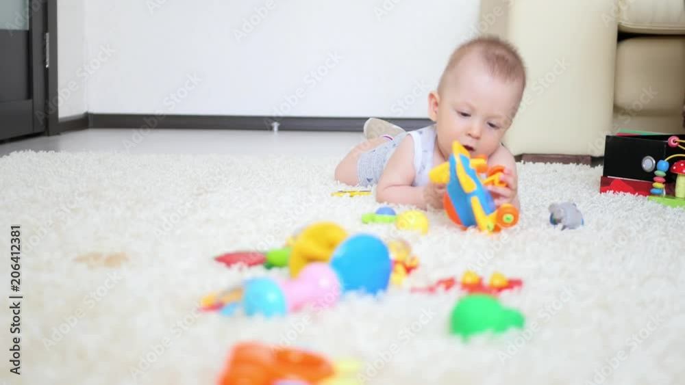 Little boy plays with toy airplane on floor with carpet. Little boy plays with toy airplane on floor with carpet.