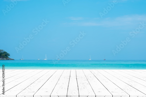 Perspective white pearl wooden table on top over blur sea in sunny day background. Beautiful sea and clouds in Thailand on summer, can be used mock up for montage products display or design layout.