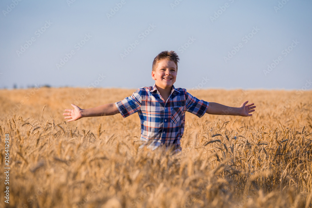 young boy running on field with ripe wheat