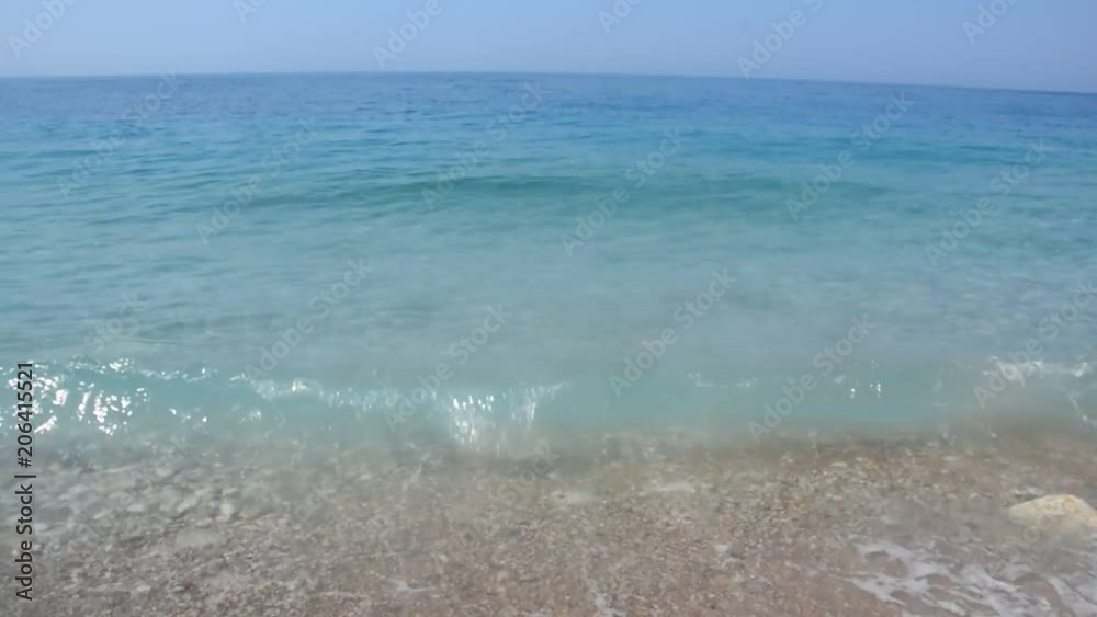 Grainy sand tropical beach, blue ocean sea wave washes the shore. Montenegro beach Grainy sand tropical beach, blue ocean sea wave washes the shore. Montenegro beach