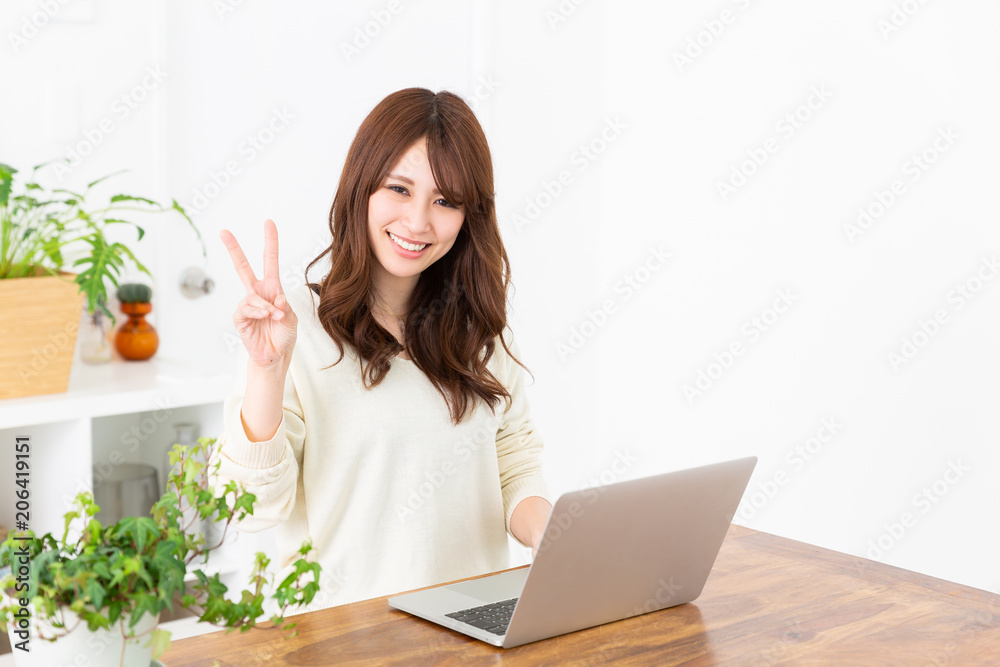部屋でラップトップコンピュータを見る女性 部屋でラップトップコンピュータを見る女性