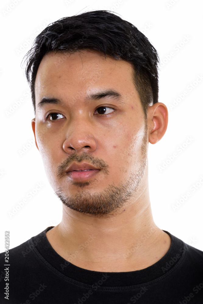 Face of young Asian man thinking while looking at distance Face of young Asian man thinking while looking at distance